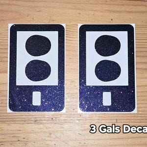 May include: Two black and white vinyl decals with a glittery finish. Each decal features a stylized image of a phone with three circles in a vertical row.