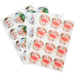 May include: A sheet of round stickers with various images, including a child eating watermelon, a child with a dog, and a couple wearing matching shirts. The stickers are white with a round, white border.