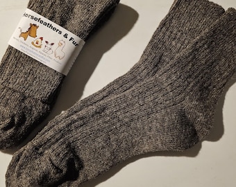 May include: Two brown wool socks with a ribbed design. One pair is folded and wrapped with a label that reads "Horsefeathers & Fur". The socks are made of a thick, warm material, perfect for cold weather.