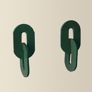 以下が含まれることがあります： リンクされたデザインの濃い緑色の楕円形のイヤリングのペア