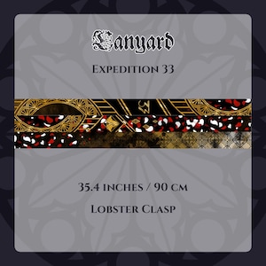 May include: A lanyard with the text "Lanyard" and "Expedition 33". The lanyard features a design with gold, black, red, and white accents. It measures 90 cm and has a lobster clasp.