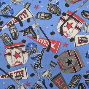 Puede incluir: Tela azul con temática de hockey. La tela presenta camisetas de hockey, discos, palos, trofeos y pancartas con las palabras "All Star" y "Champions".