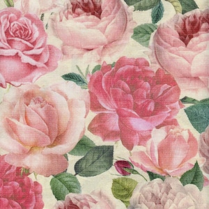 May include: A fabric featuring a dense, repeating pattern of blooming roses in various shades of pink, ranging from soft blush to deep magenta. The floral design includes detailed green leaves and small buds set against a cream-coloured background.