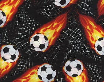 Flaming Soccer Balls into the Net on Black by Timeless Treasures