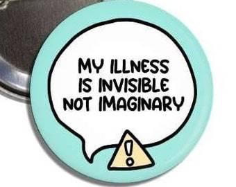 May include: A round pin-back button with a light blue background featuring a white speech bubble containing the black text MY ILLNESS IS INVISIBLE NOT IMAGINARY and a small yellow triangle with an exclamation point at the bottom.