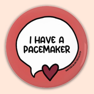 May include: A round, red button with a white speech bubble containing the text "I HAVE A PACEMAKER" in black. A maroon heart is below the speech bubble. The words "WATERCOLOR FRECKLES" are in the lower right corner.