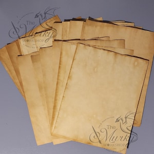 May include: A stack of aged, parchment-style paper sheets with a sepia tone. The paper has a slightly textured appearance and visible spots, suggesting an antique or vintage aesthetic. The watermark "The Murky Workshop" is visible in the lower right corner.