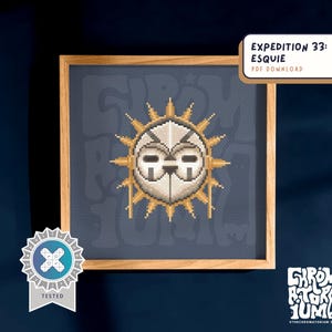 Può includere: Opera d'arte a punto croce in una cornice di legno. Il design presenta un emblema solare con un volto centrale a forma di maschera, circondato da raggi dorati. Lo sfondo è un tessuto blu scuro. Il testo sull'immagine recita "EXPEDITION 33: ESQUIE PDF DOWNLOAD".
