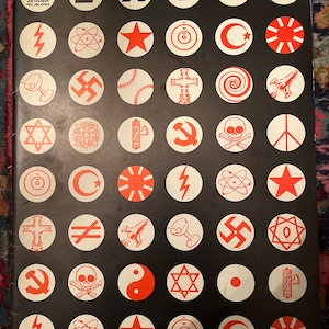 May include: A black and white poster with the word "EXIT" in large white letters. The poster is divided into a grid of 49 circles, each containing a different symbol in red. The symbols include a lightning bolt, an atom, a star, a circle with a dot in the center, a crescent moon, a rising sun, a martini glass, a swastika, a baseball, a cross, a spiral, a spaceship, a star of David, a flower, a light bulb, a hammer and sickle, a skull and crossbones, a peace sign, a yin yang symbol, and a Japanese flag.