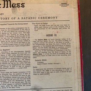 May include: A close-up of the back cover of a record album titled "Mass" by Anton LaVey. The album cover is red and features a black and white image of a pentagram with a goat's head inside. The text "Story of a Satanic Ceremony" is printed in white letters on the cover. The album is compatible with stereo systems.