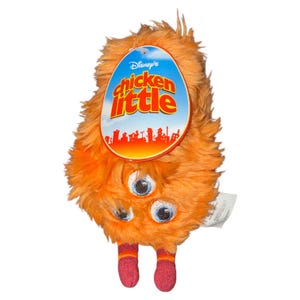 Könnte beinhalten: Ein orangefarbenes Chicken Little-Plüschtier mit drei Augen und zwei roten Füßen mit orangefarbenen Streifen. Das Spielzeug hat eine flauschige Textur und ein Etikett mit dem Logo des Films.