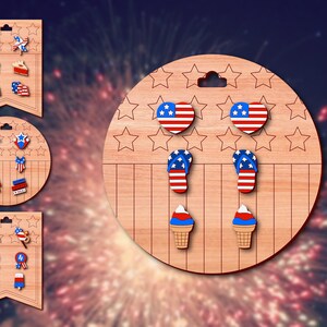 May include: A set of six pairs of red, white, and blue earrings on a wooden display. The earrings feature various patriotic designs, including stars, fireworks, ice cream cones, and flip-flops.