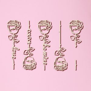 May include: Four wooden rose cutouts with the words "love", "always", "be mine", and a blank cutout. The roses are white and the words are in a cursive font.
