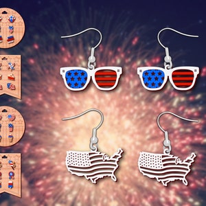 May include: Four pairs of dangle earrings with a patriotic theme. The earrings feature red, white, and blue stars, stripes, and an outline of the United States.