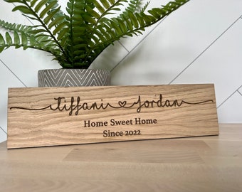 May include: A wooden sign with the text "Tiffany & Jordan Home Sweet Home Since 2022" engraved on it.