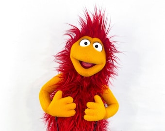Professionelle Handpuppe im Muppet-Stil. Entzückendes orangefarbenes und rotes Pelzmonster mit zwei Armstangen