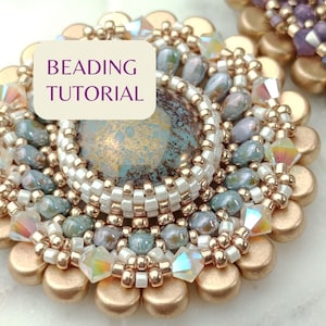 May include: A close-up of a beaded jewellery piece with a turquoise and gold-toned cabochon in the centre. The piece is surrounded by gold-toned beads and iridescent glass beads. The text "BEADING TUTORIAL" is visible in the image.
