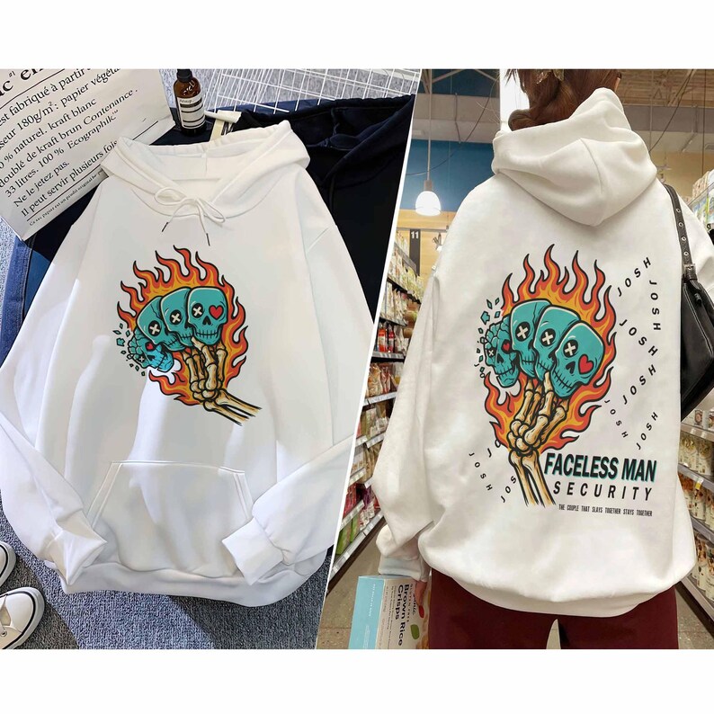Puede incluir: Sudadera con capucha blanca con un dise&ntilde;o frontal de tres calaveras turquesas rodeadas de llamas naranjas y una mano esquel&eacute;tica. La parte trasera presenta el mismo dise&ntilde;o y el texto "FACELESS MAN SECURITY".