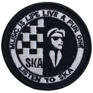 Op de afbeelding: Zwart-witte geborduurde patch met de tekst "Music is Life Live a Fun One Listen to Ska" in een cirkel rond een geruit patroon en een silhouet van een persoon met een hoed en zonnebril.