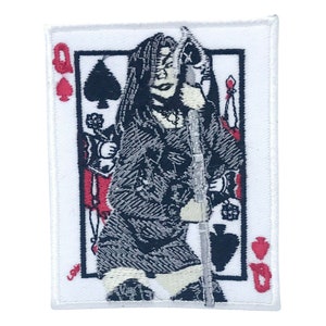 Könnte beinhalten: Ein weißer gestickter Aufnäher mit der Spielkarte der Dame Pik. Die Dame ist in einem schwarzen Kleid mit weißem Kragen dargestellt und hält ein Schwert. Die Karte ist schwarz umrandet und hat rote Akzente.