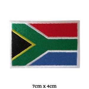 May include: An embroidered South African flag patch with a white border. The flag features the colors black, yellow, green, red, and blue. The patch is 7 inches by 4 inches.