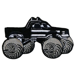May include: Black and white embroidered patch of a monster truck with large tyres.