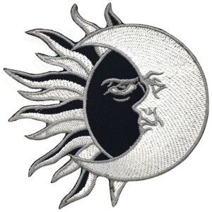 May include: A black and white embroidered patch featuring a sun and moon design. The sun has a stylised, flame-like design and the moon is crescent shaped with a face.