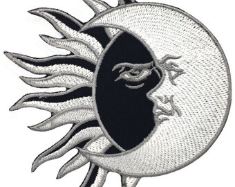 May include: A black and white embroidered patch featuring a sun and moon design. The sun has a stylised, flame-like design and the moon is crescent shaped with a face.