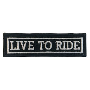 May include: Black embroidered patch with white stitching that reads "LIVE TO RIDE" in a rectangular frame.