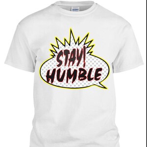 May include: White t-shirt with a yellow and black comic book speech bubble that says "Stay! Humble".