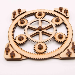 May include: A wooden gear set with eight interlocking gears, all connected to a central hub. The gears are made of light brown wood with dark brown accents.