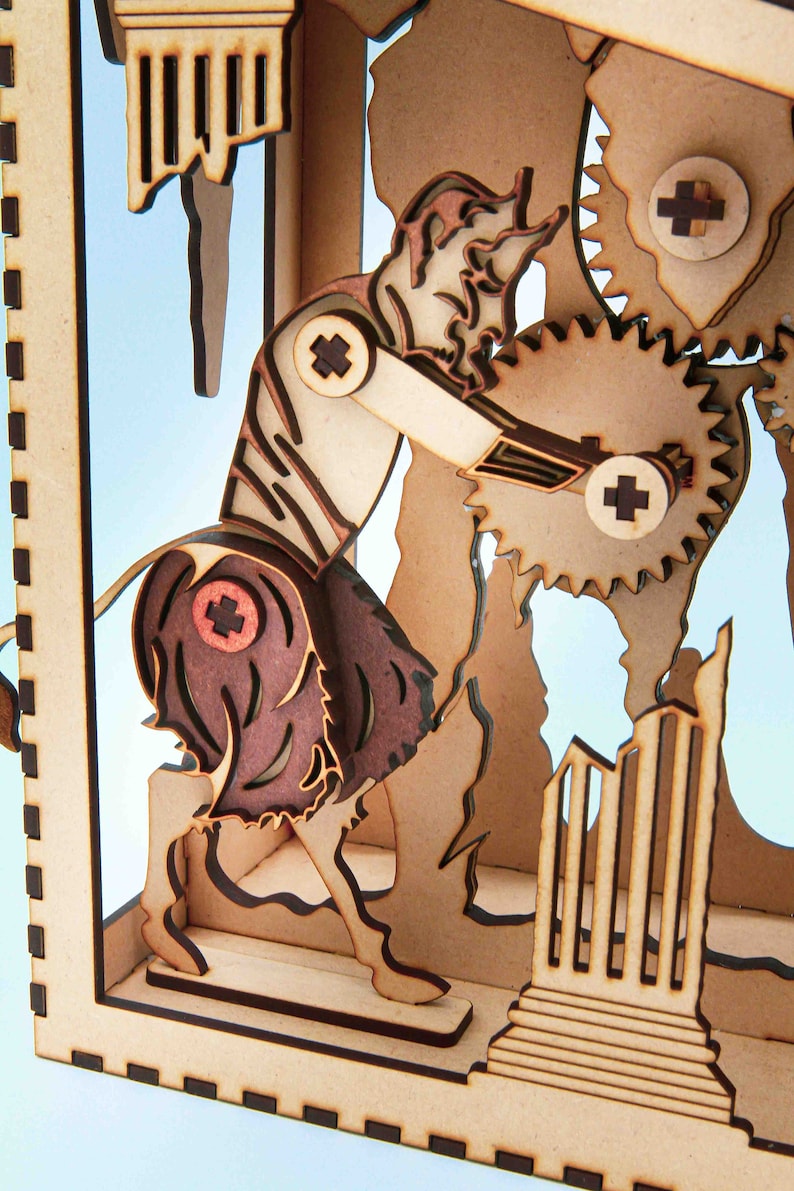 May include: A wooden model of a figure turning a large gear. The figure is wearing a skirt and has a beard. The model is made of light brown wood and has a blue background.