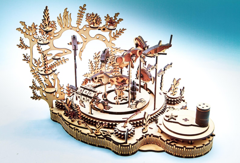 May include: A wooden laser-cut carousel featuring an underwater theme. The carousel has various sea creatures, including fish and turtles, and is decorated with coral and seaweed. The carousel is made of light brown wood and has intricate details.
