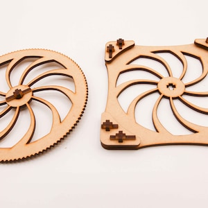 May include: Two wooden gears with a spiral design. The larger gear is round and the smaller gear is square.