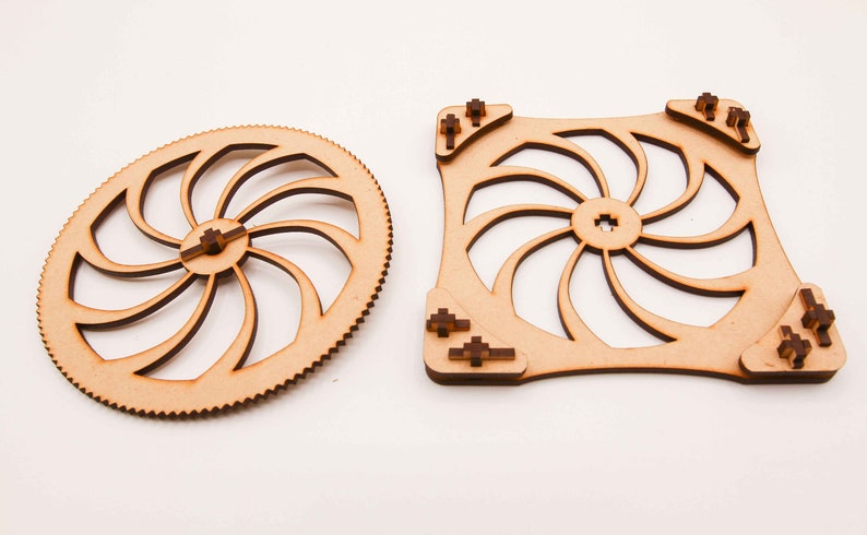 May include: Two wooden gears with a spiral design. The larger gear is round and the smaller gear is square.