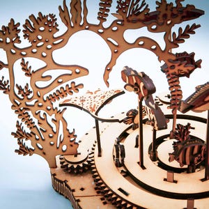 May include: A wooden, laser-cut model of an underwater scene, featuring coral, fish, and other marine life. The model is made of light brown wood and has intricate details, including cut-out designs and layered elements.