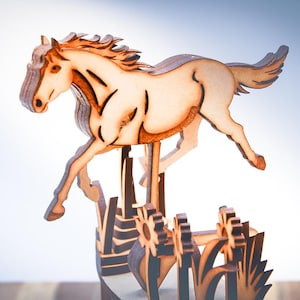 May include: A wooden sculpture of a horse in mid-leap, with detailed cutouts. The horse is light brown with darker brown accents, and is mounted on a base with stylized flowers and grass. The background is a gradient of white to blue.