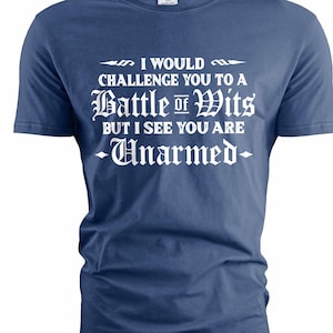 Könnte beinhalten: Ein marineblaues T-Shirt mit weißem Text. Der Text lautet: „ICH WÜRDE DICH ZU EINEM GEISTESKAMPF HERAUSFORDERN, ABER ICH SEHE, DASS DU UNBEWAFFNET BIST.“