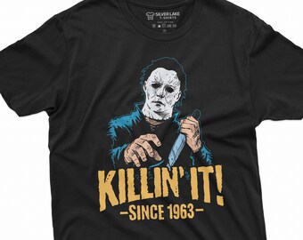 May include: Black t-shirt featuring a graphic of a masked figure holding a knife. The text "Killin' It! -Since 1963- " is printed below the figure.