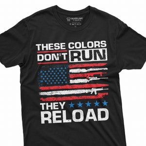 May include: Black t-shirt with a distressed American flag design and the text "These colors don't run, they reload".