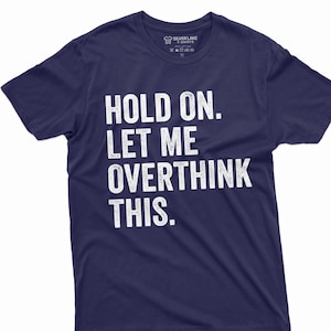May include: Navy blue t-shirt with white text that reads "HOLD ON. LET ME OVERTHINK THIS."