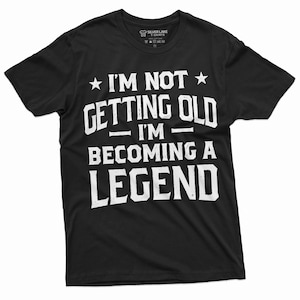 May include: Black t-shirt with white text that reads "I'm not getting old - I'm becoming a legend."