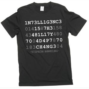 Puede incluir: Camiseta negra con texto blanco y gris. El texto incluye una serie de números y letras, con el nombre "HAWKING" en la parte inferior. La camiseta es de cuello redondo.