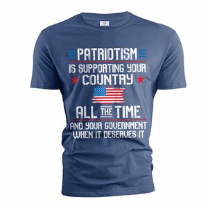 Puede incluir: Una camiseta azul marino con un gr&aacute;fico blanco desgastado que dice "El patriotismo es apoyar a tu pa&iacute;s todo el tiempo y a tu gobierno cuando se lo merece". El gr&aacute;fico tambi&eacute;n incluye una bandera estadounidense roja, blanca y azul.