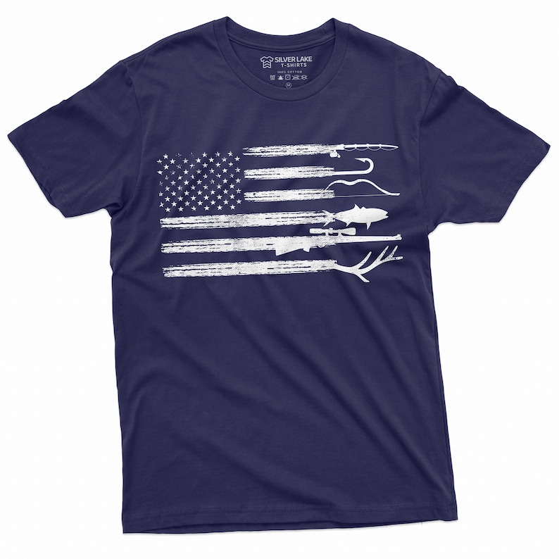 May include: A navy blue t-shirt with a white distressed American flag design. The flag is made up of various hunting and fishing items, including a rifle, a fish, a bow and arrow, and a fishing rod.
