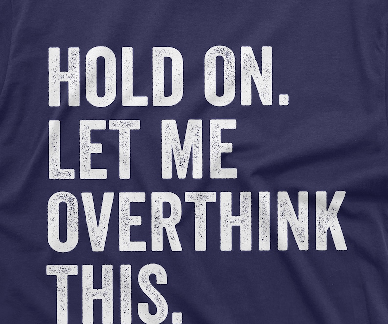 May include: A navy blue t-shirt with white text that reads "HOLD ON. LET ME OVERTHINK THIS."