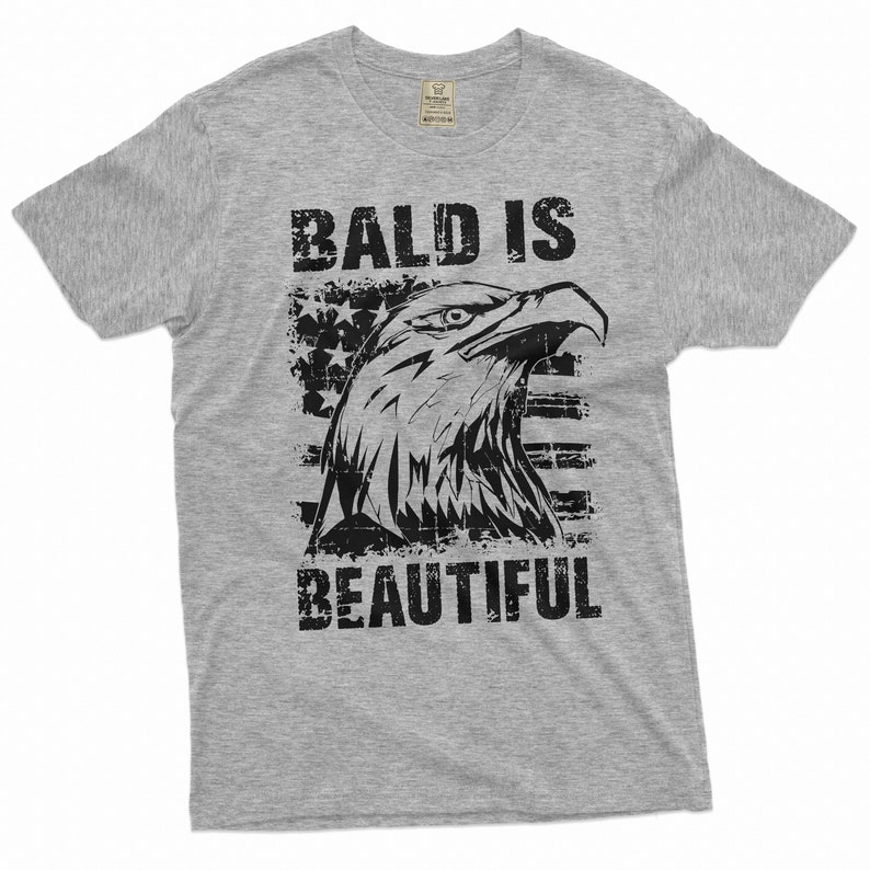 May include: Gray t-shirt with a distressed black graphic of an eagle's head with an American flag behind it. The text "Bald is Beautiful" is printed below the eagle.