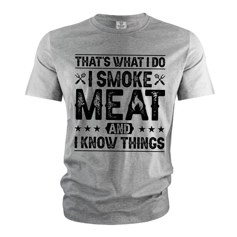 May include: Gray t-shirt with a black graphic that says "That's what I do I smoke meat and I know things". The graphic includes a fork and knife and a flame.