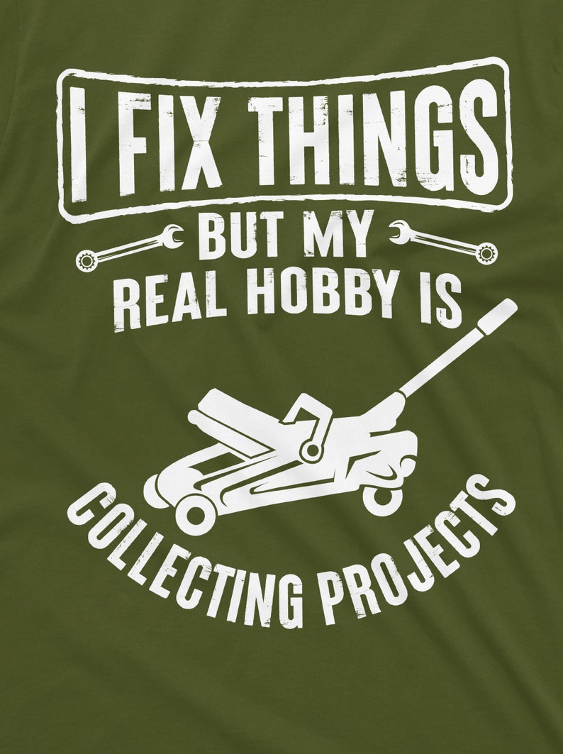 May include: A green t-shirt with white text that reads "I fix things but my real hobby is collecting projects". A white silhouette of a car jack is below the text.