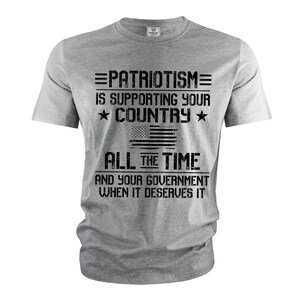 Puede incluir: Camiseta gris con un estampado gr&aacute;fico negro que dice "=PATRIOTISM= IS SUPPORTING YOUR ★ COUNTRY ★ ALL THE TIME AND YOUR GOVERNMENT WHEN IT DESERVES IT".